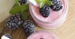 Enjoy a refreshing blackberry smoothie topped with fresh mint leaves, perfect for a summer treat.